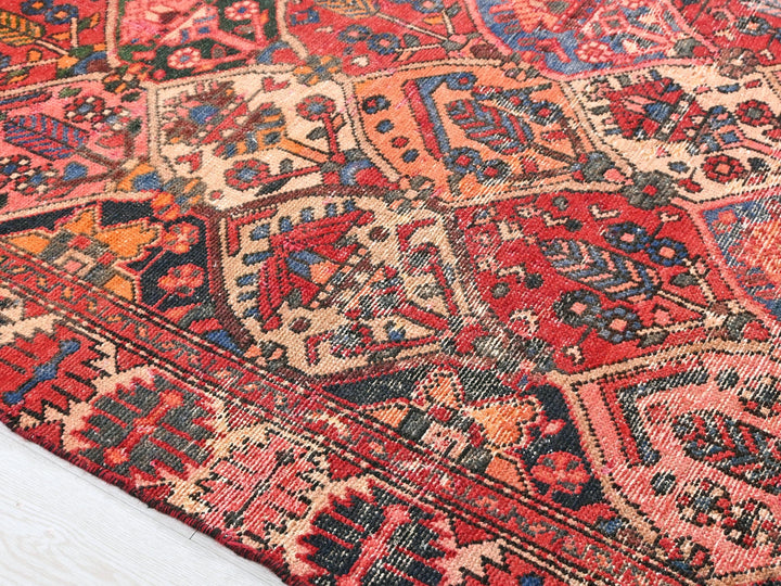 a red and blue oriental rug on a white floor