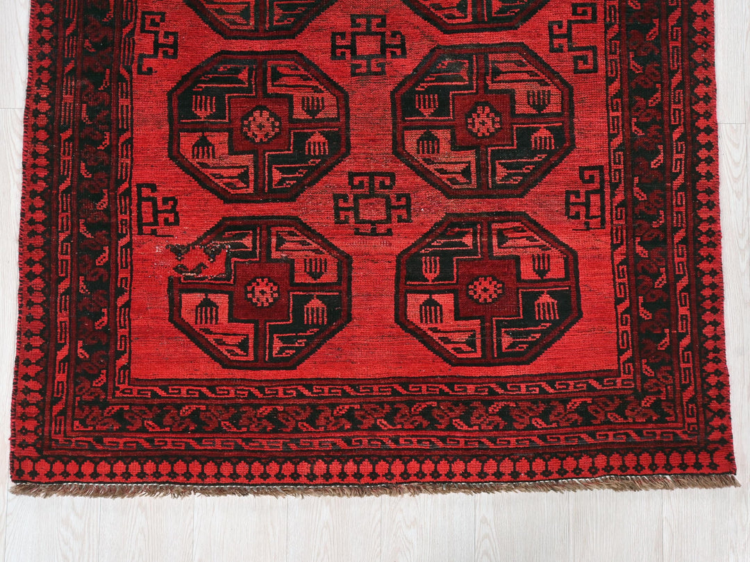 a red and black rug on a white floor