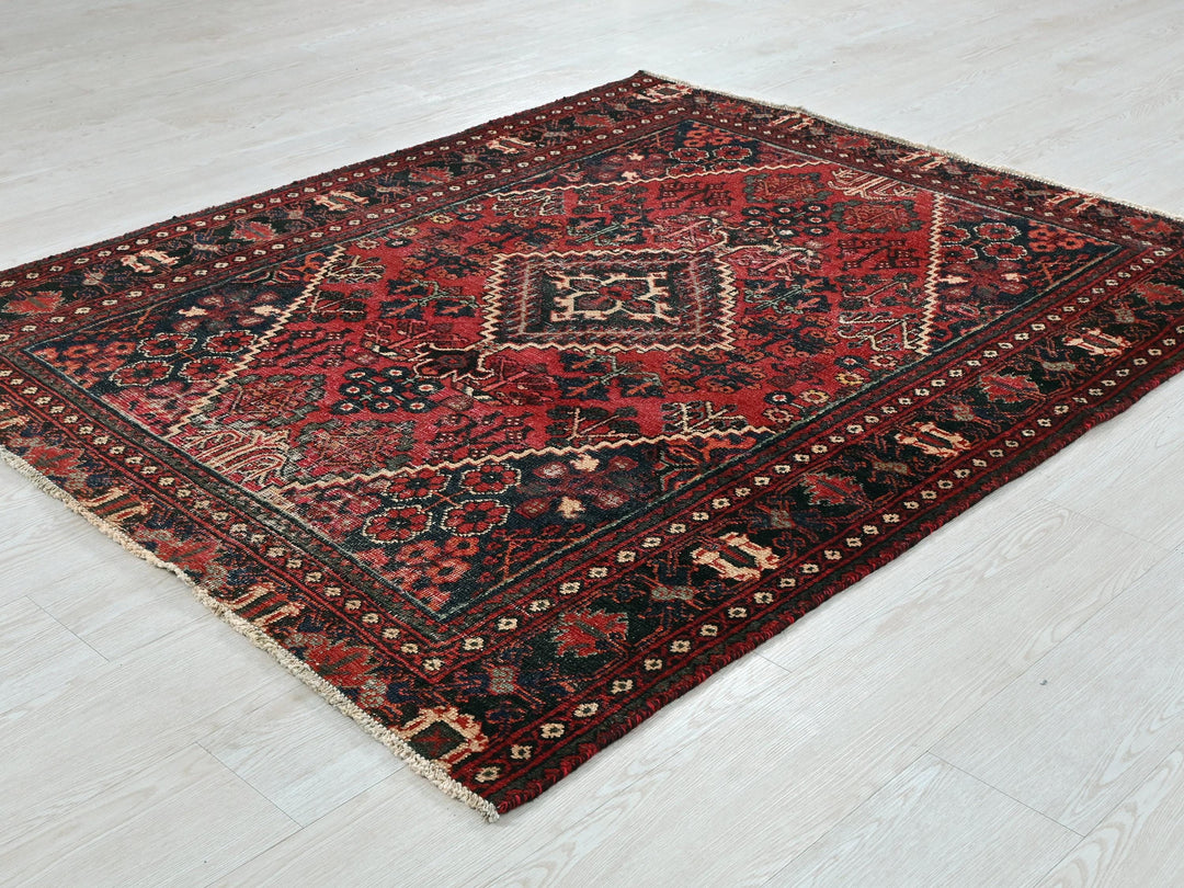 a red and black rug on a white floor