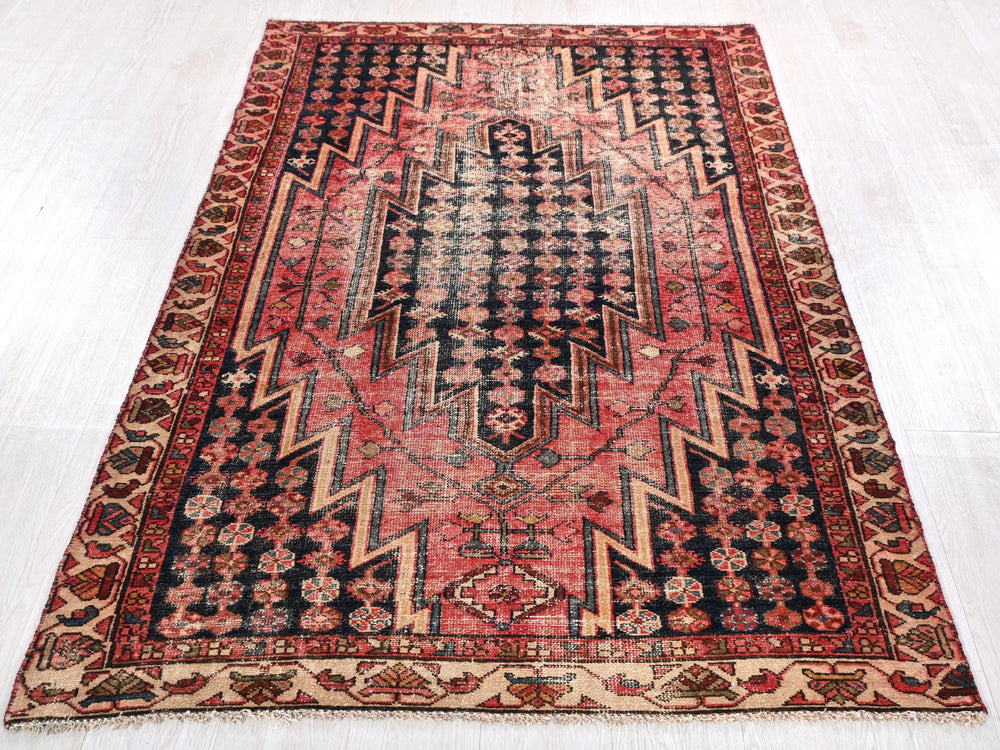 a red and black rug on a white floor