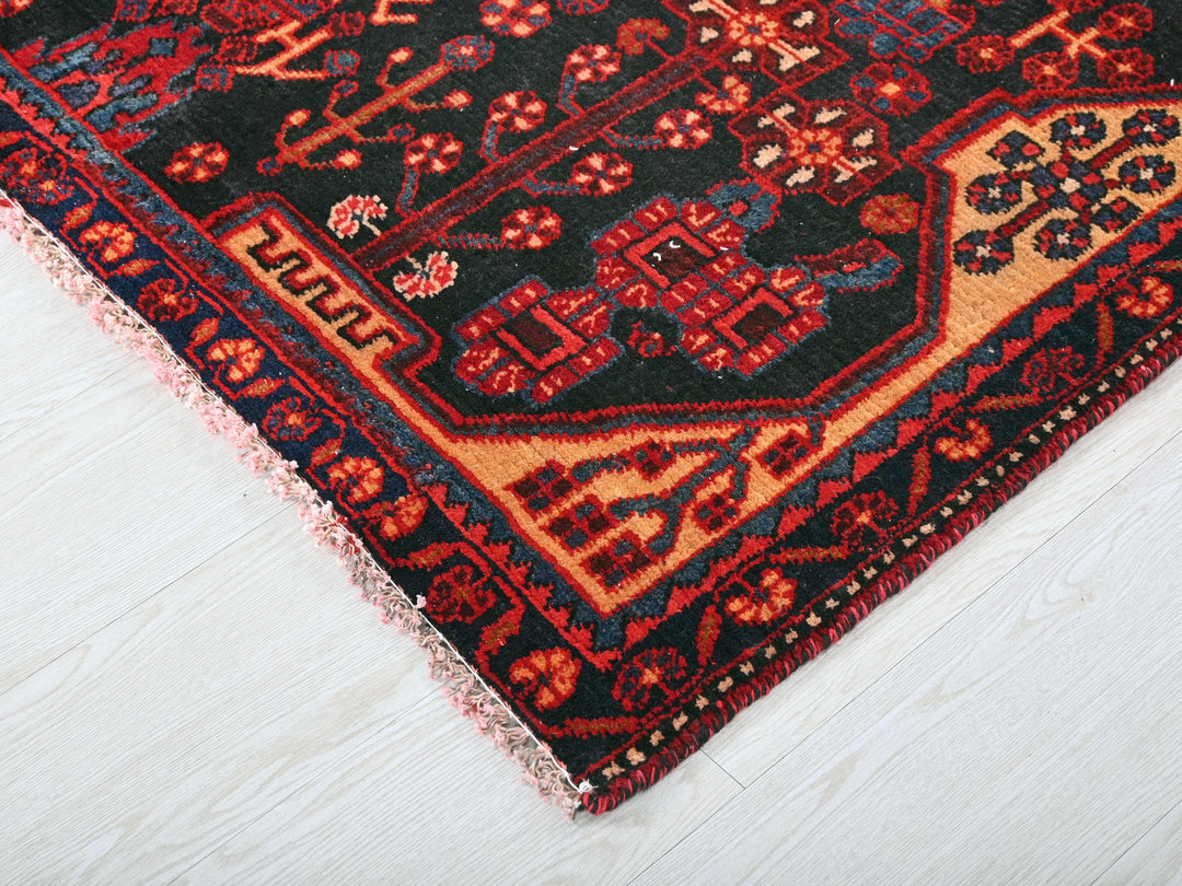 a red and black oriental rug on a white floor