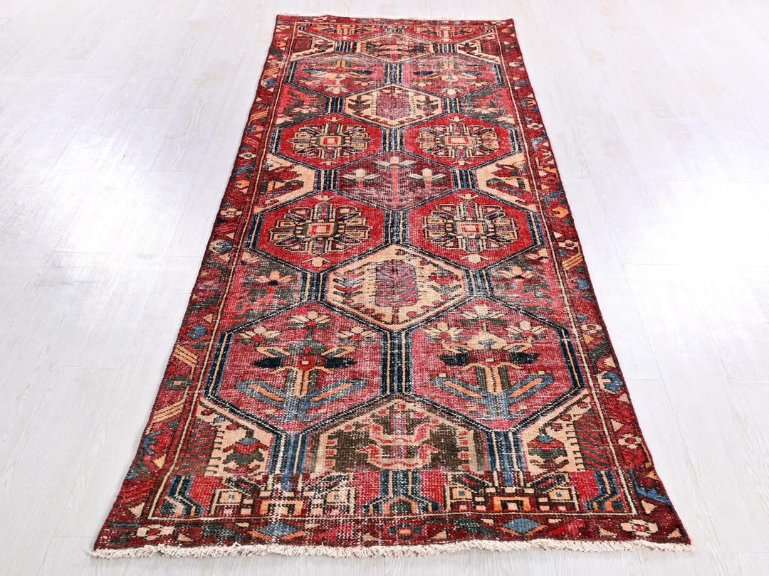 a red oriental rug on a white wooden floor