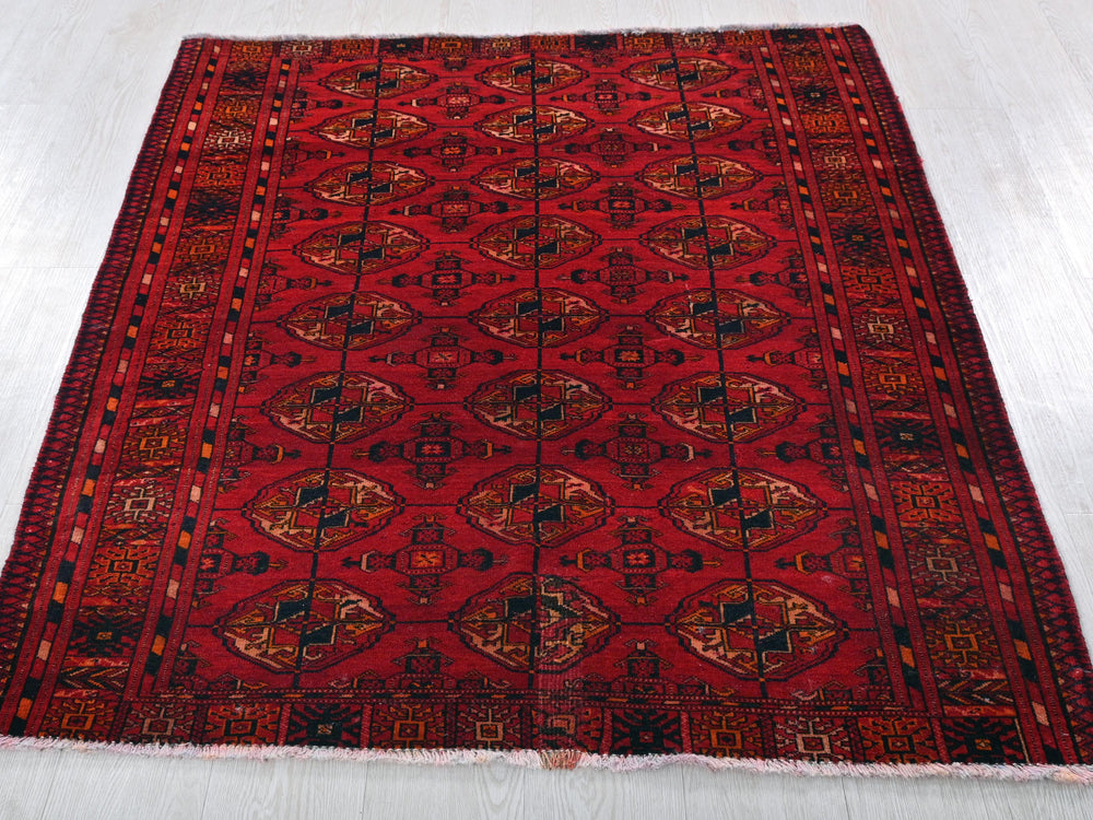 a red rug with a pattern on the middle of it