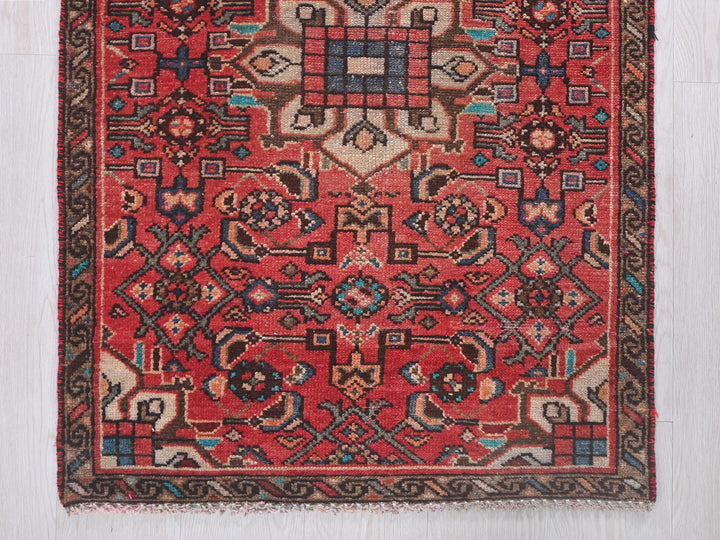a red rug with a design on the middle of it