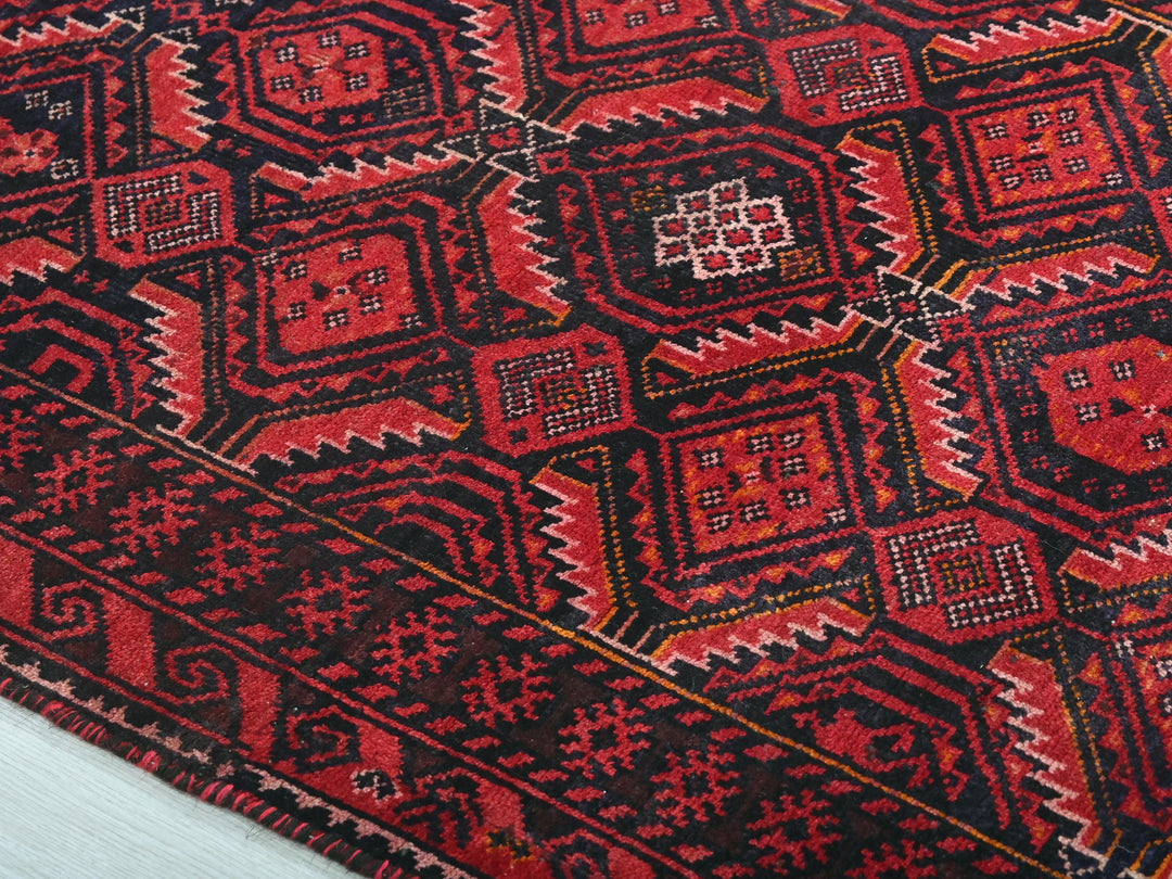 a close up of a red and black oriental rug