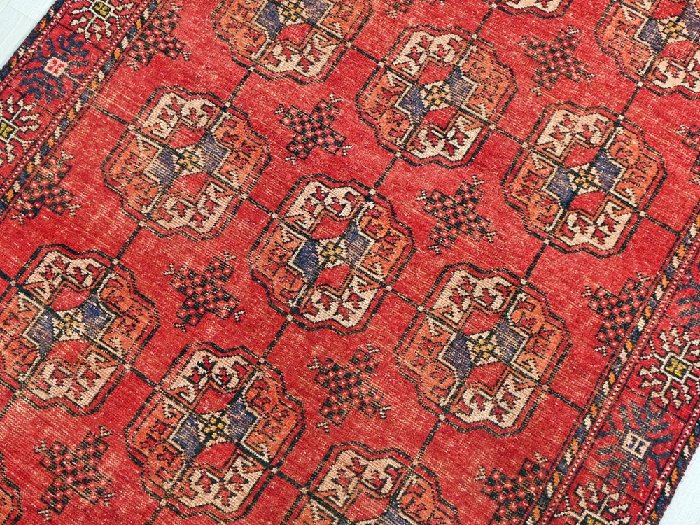 a red rug with a pattern on it