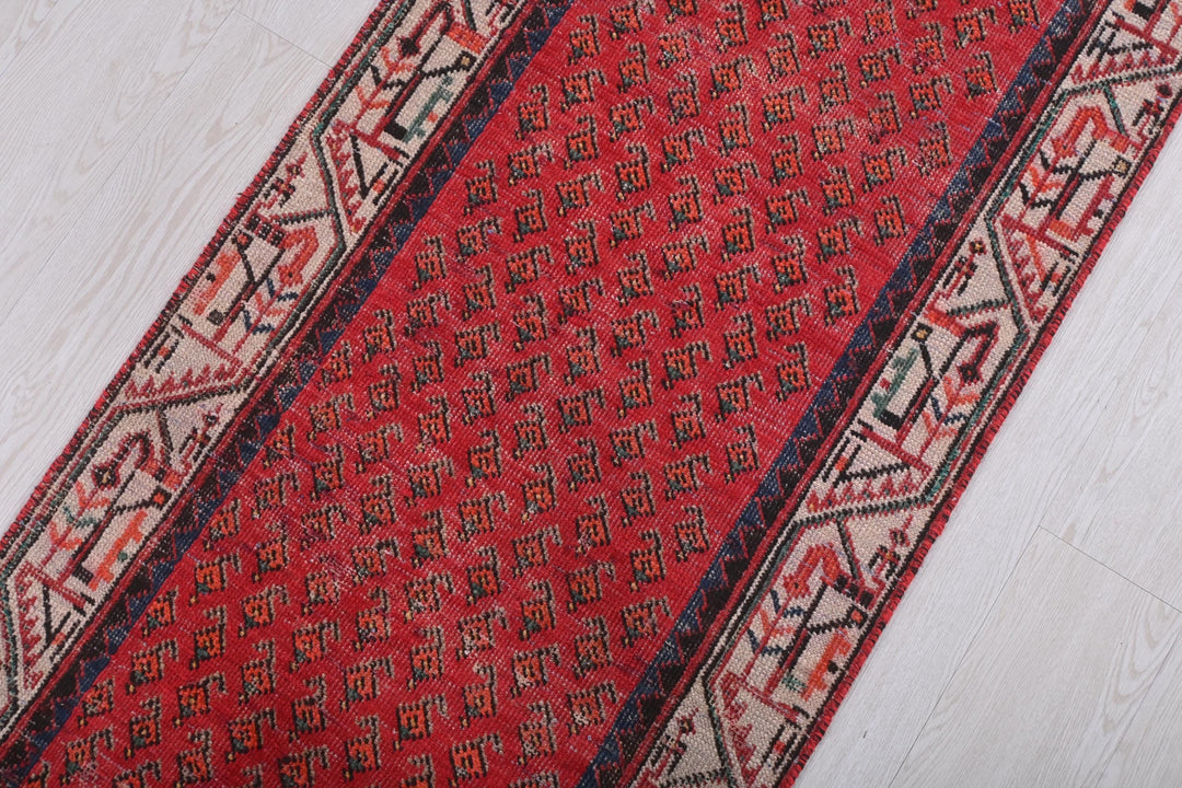 a red rug with a blue border on a white floor