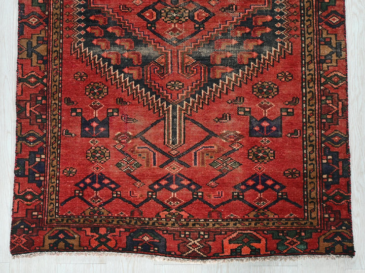 a red rug with a design on the middle of it