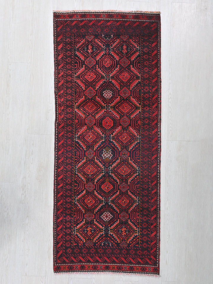 a red rug hanging on a white wall
