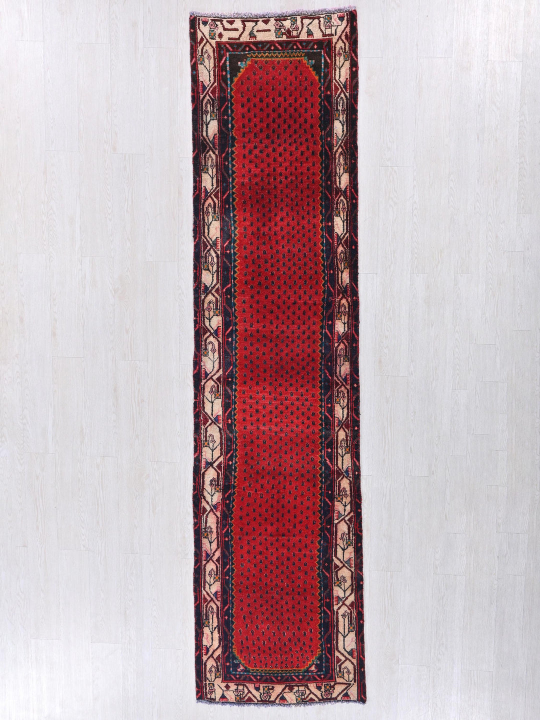 a red rug hanging on a white wall
