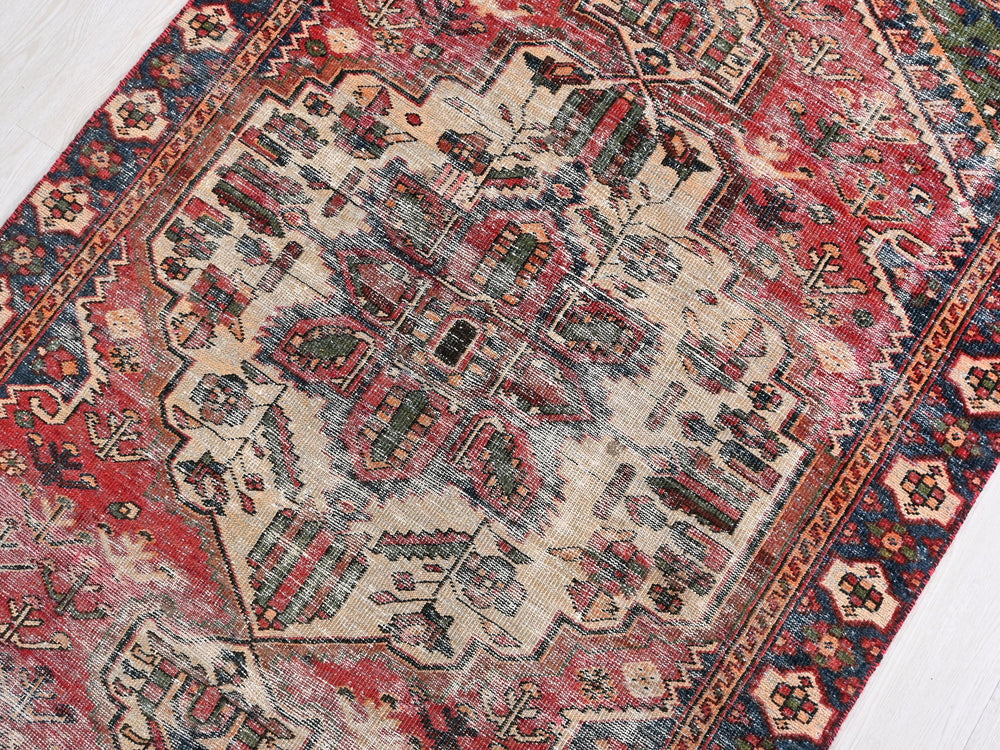 a red and blue oriental rug on a white floor