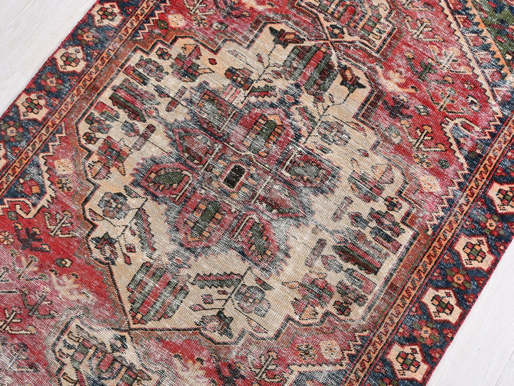 a red and blue oriental rug on a white floor