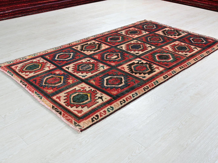 a red and black rug sitting on top of a white floor