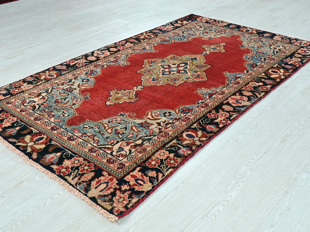 a red and black rug on a white floor