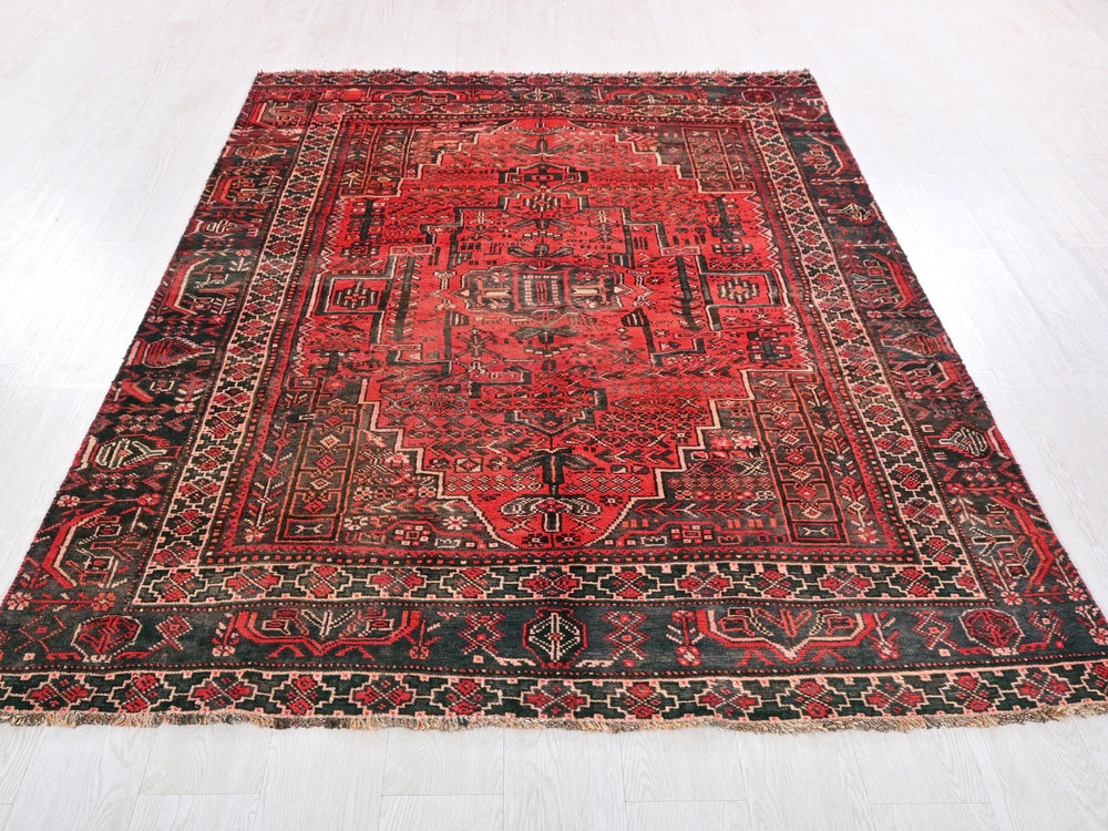 a red and black oriental rug on a white floor