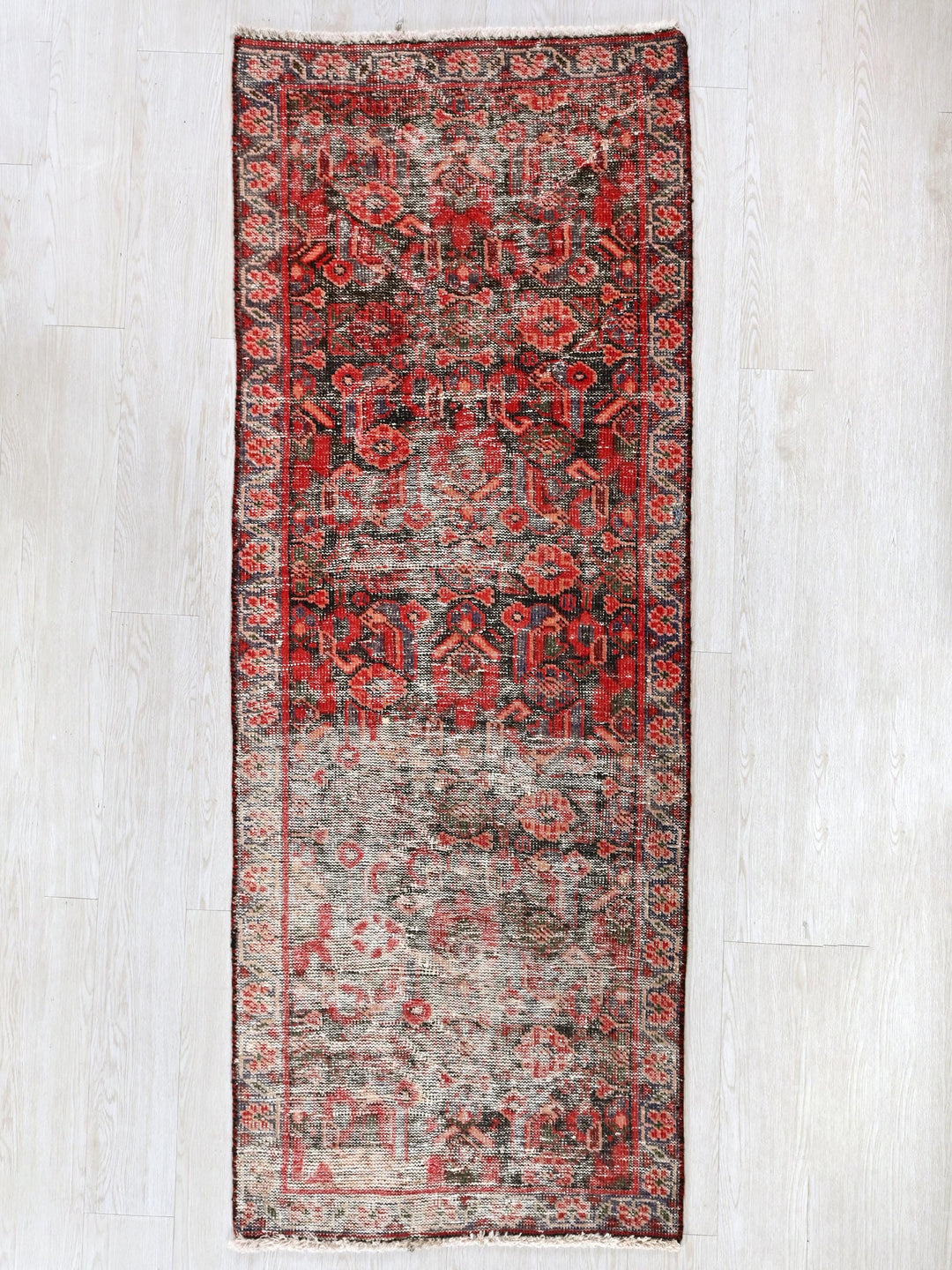 a red and gray rug on a white floor