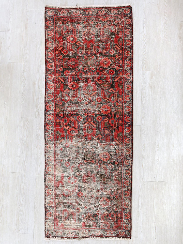 a red and gray rug on a white floor