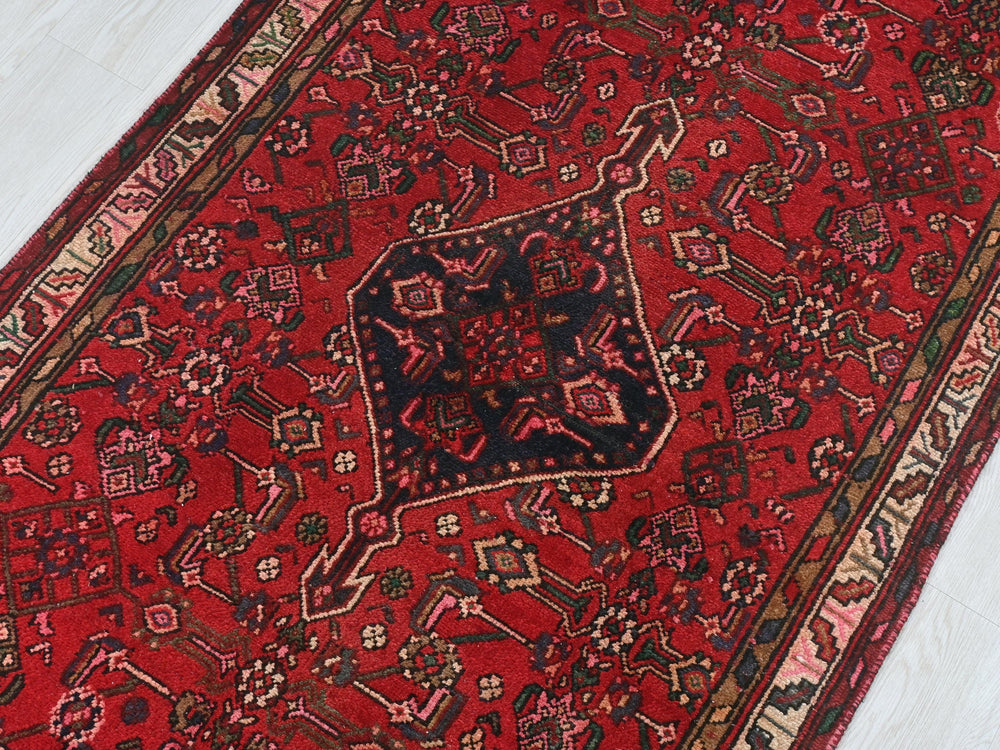 a red oriental rug on a white floor
