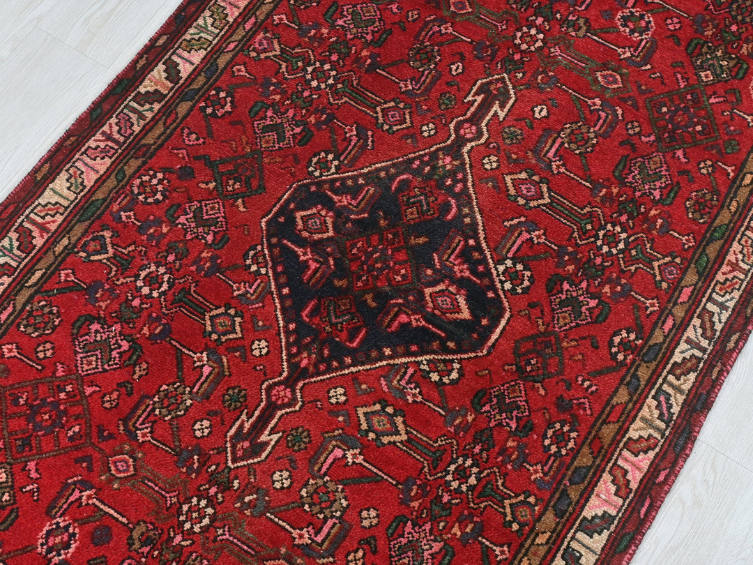 a red oriental rug on a white floor