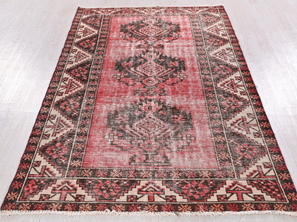 a red and black rug on a white floor