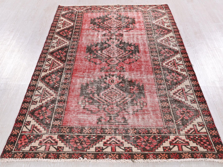 a red and black rug on a white floor