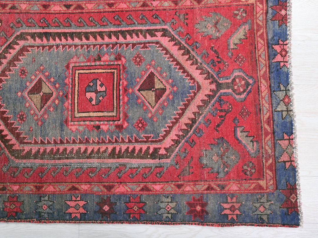 a red and blue rug on a white floor