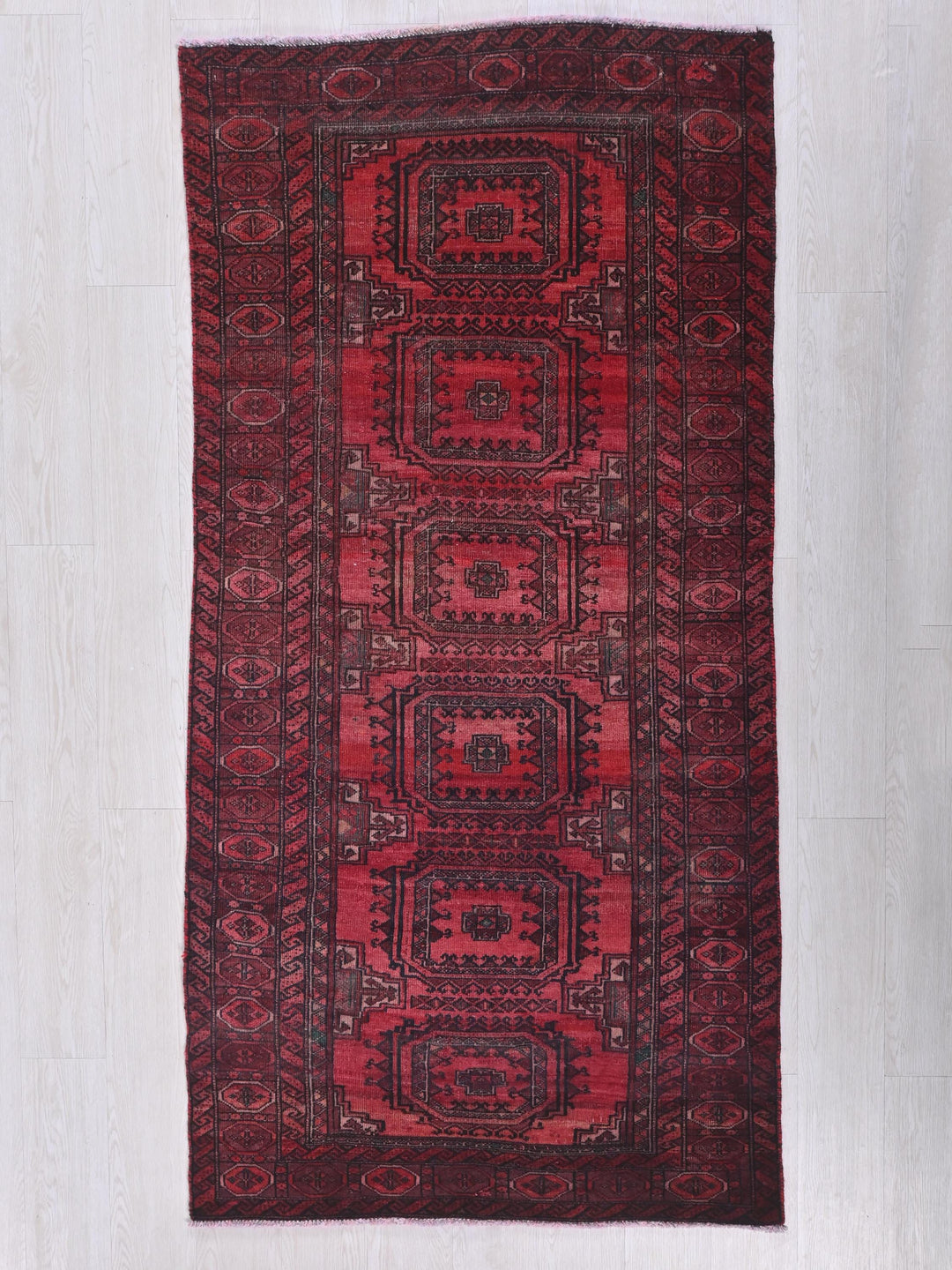 a red rug with a design on the middle of it