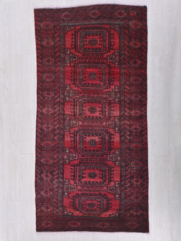 a red rug with a design on the middle of it