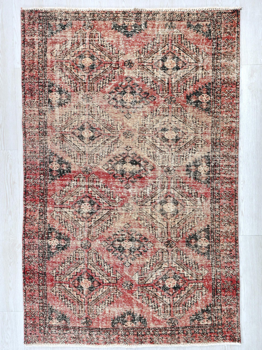a red and black rug on a white floor