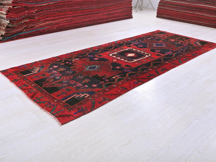 a pile of red rugs sitting on top of a white floor