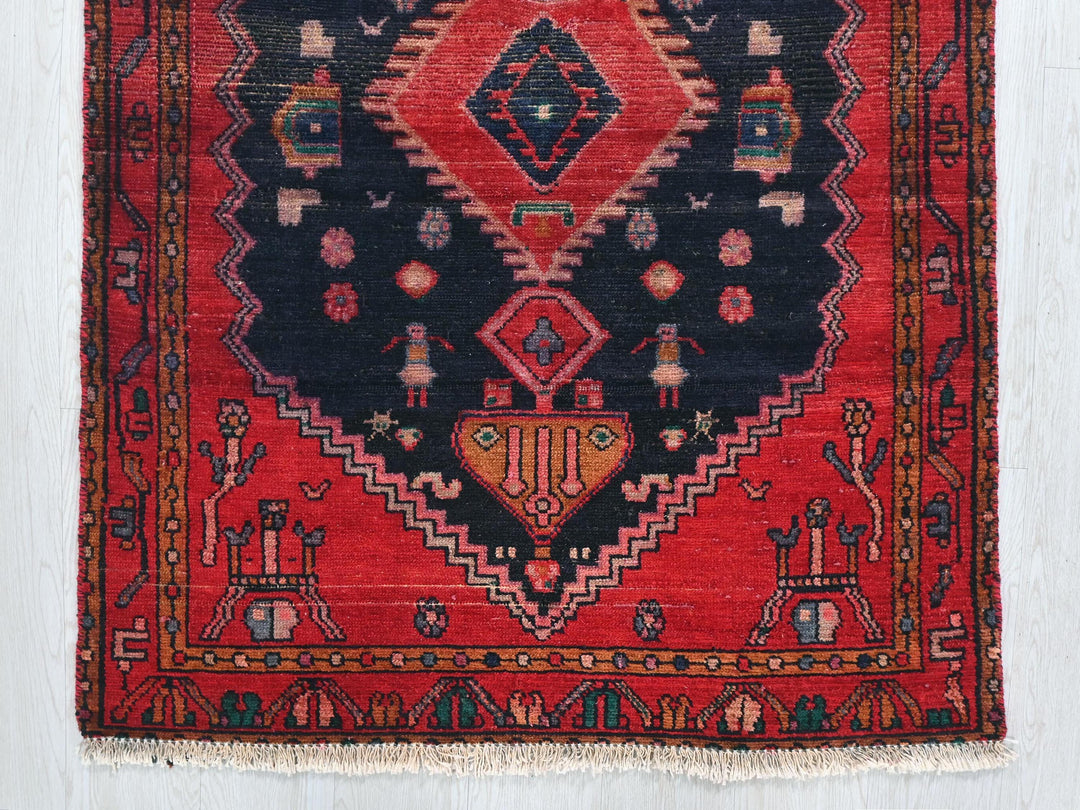 a red and black oriental rug hanging on a wall