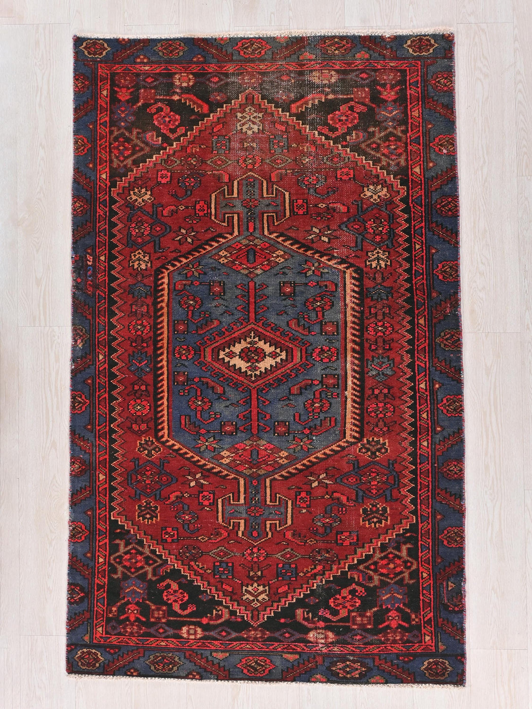 a red and blue rug on a white floor