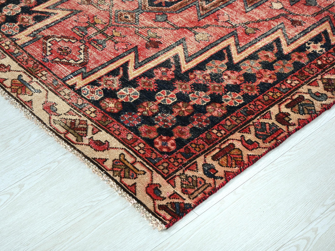 a red and black oriental rug on a white floor