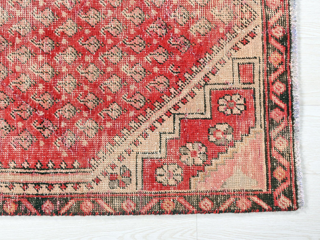 a red and black rug on a white floor