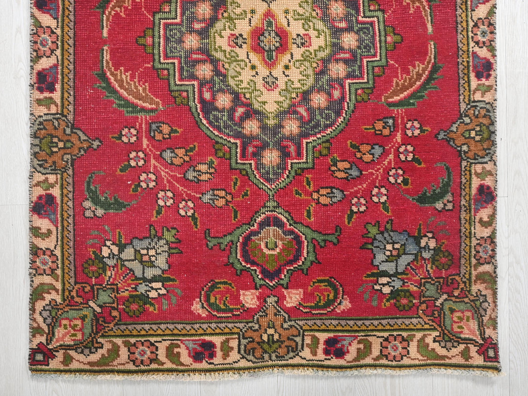 a red rug with a floral design on it