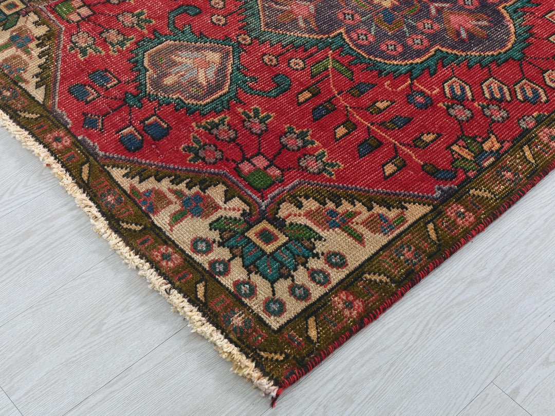 a red oriental rug on a white wooden floor