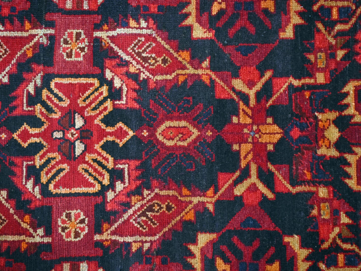 a close up of a red and black oriental rug