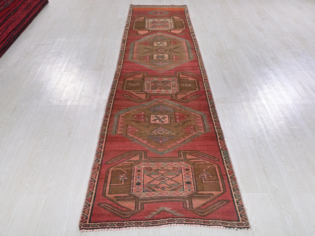 a long red runner rug on a white floor