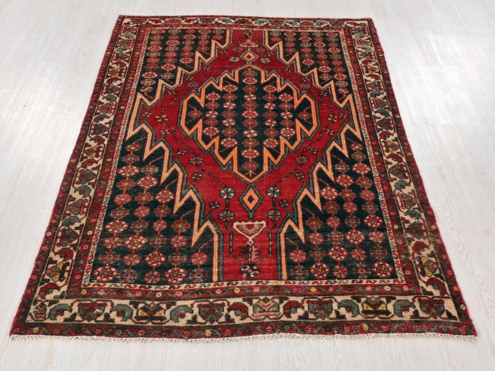 a red and black rug on a white floor