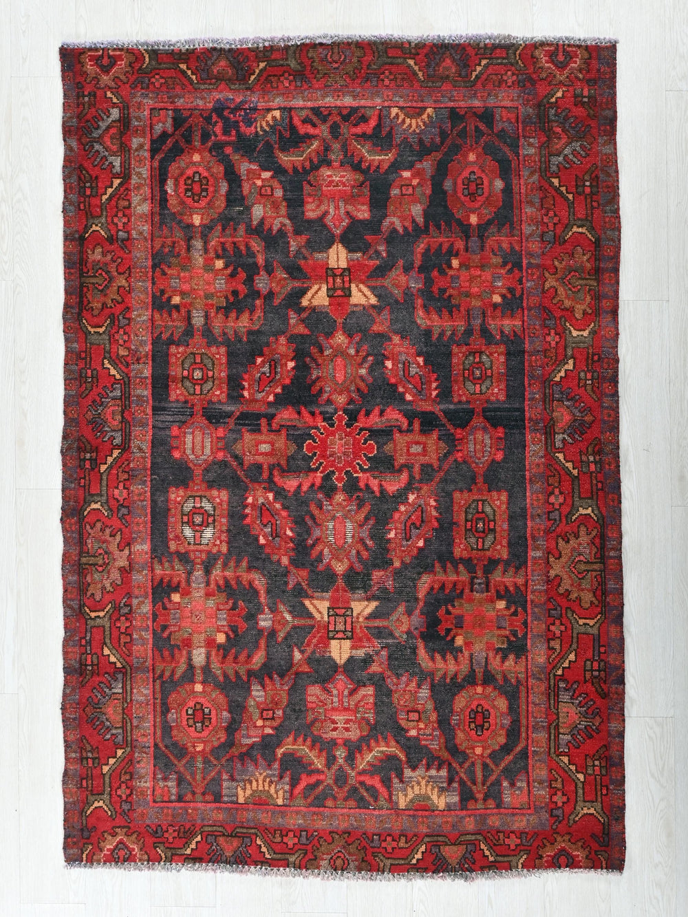 a red and black rug on a white wall