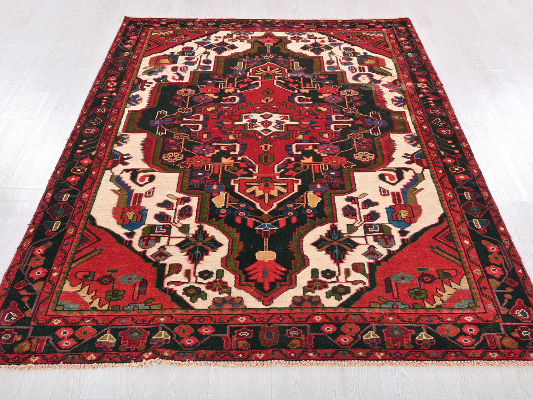 a red and black oriental rug on a white floor