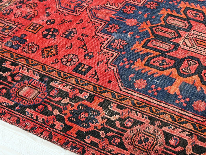 a red and blue oriental rug on a white floor