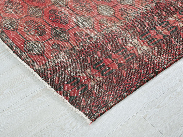 a red and black rug on a white floor