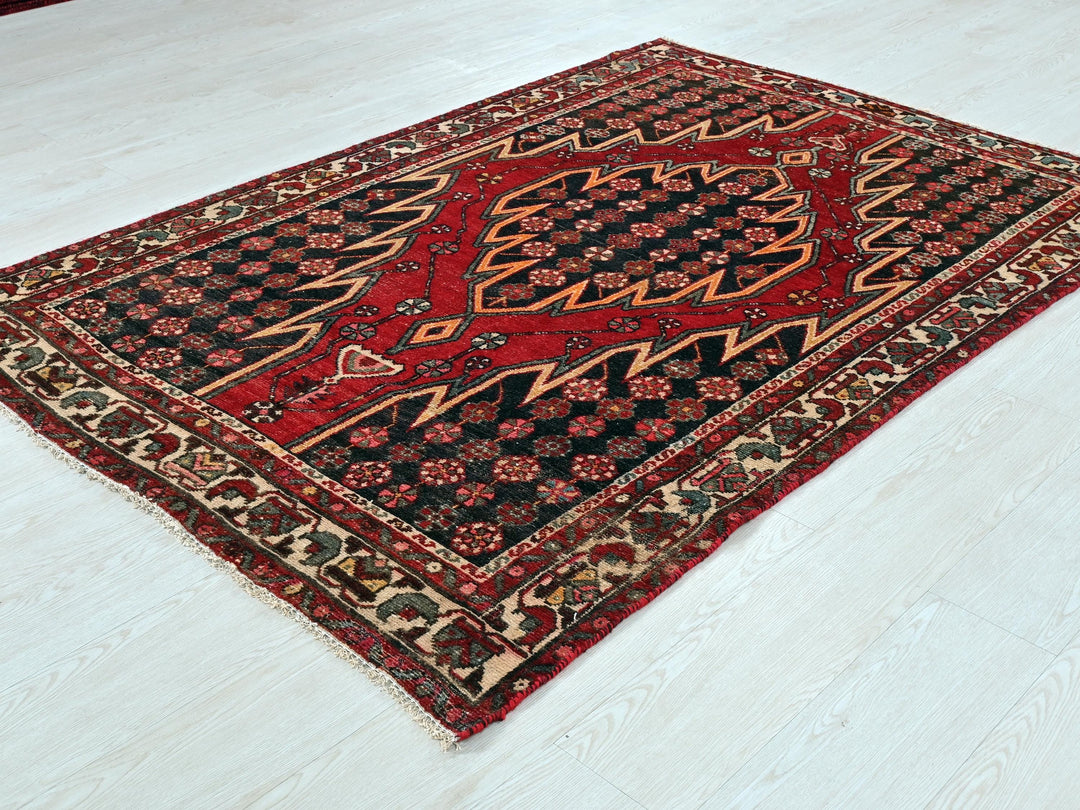 a red and black rug sitting on top of a white floor