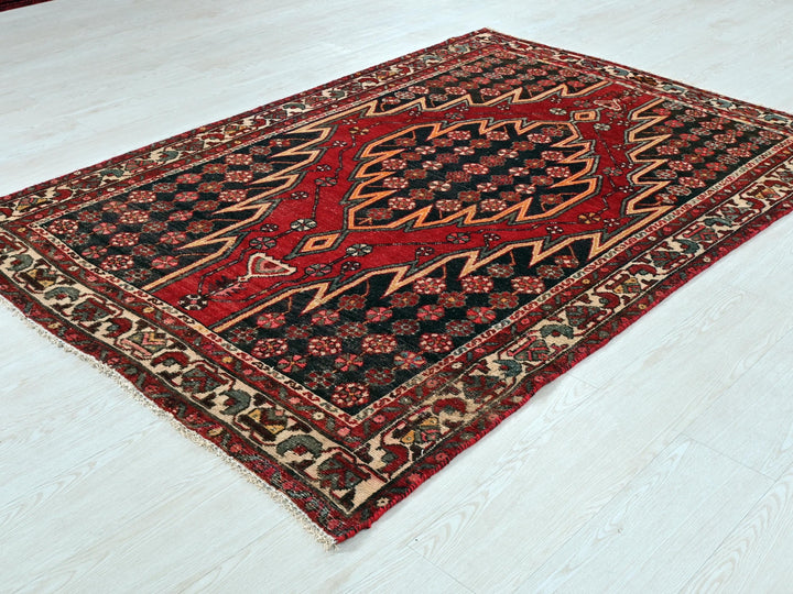 a red and black rug sitting on top of a white floor