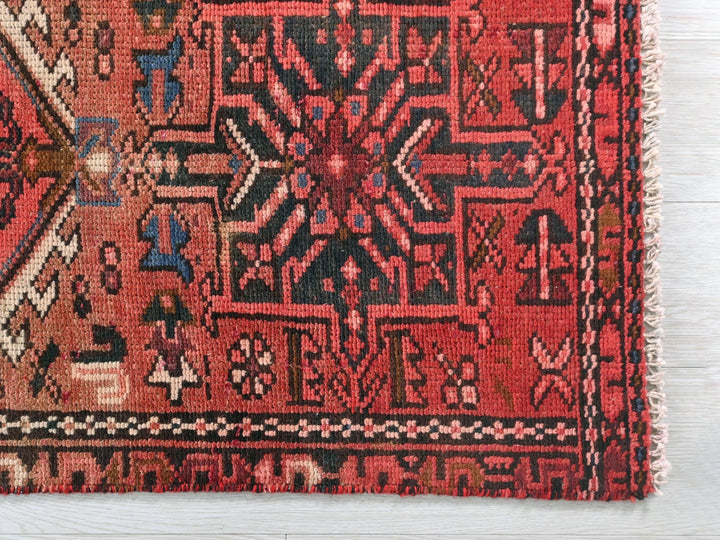 a red oriental rug on a white wooden floor