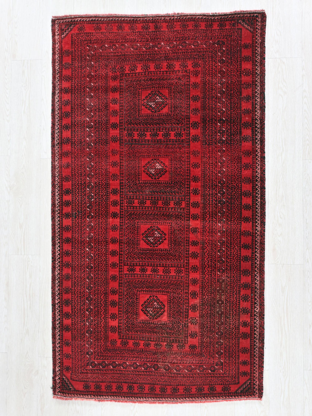 a red rug on a white wooden floor