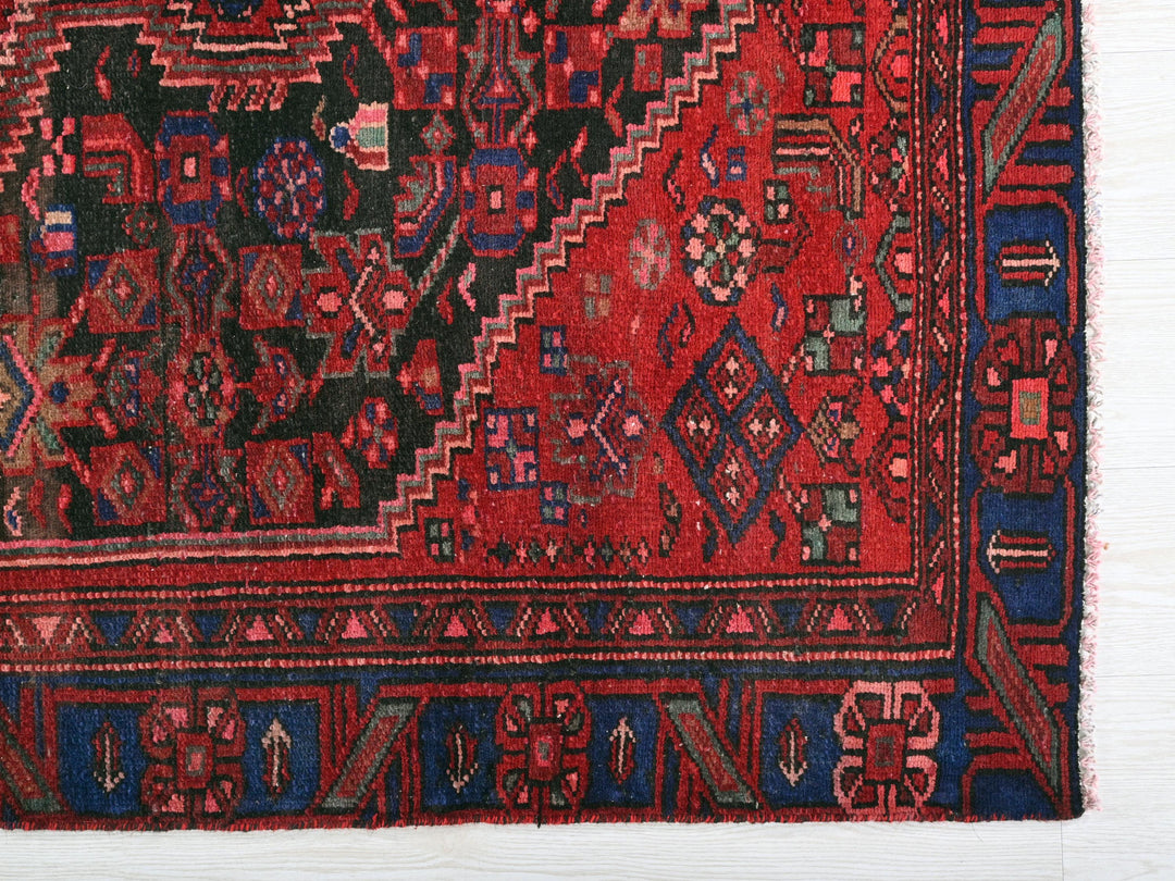 a red rug with blue and red designs on it