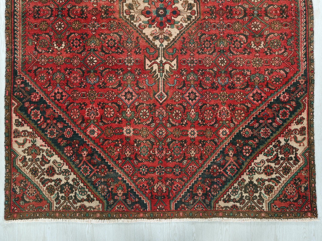 a red rug with a floral design on it