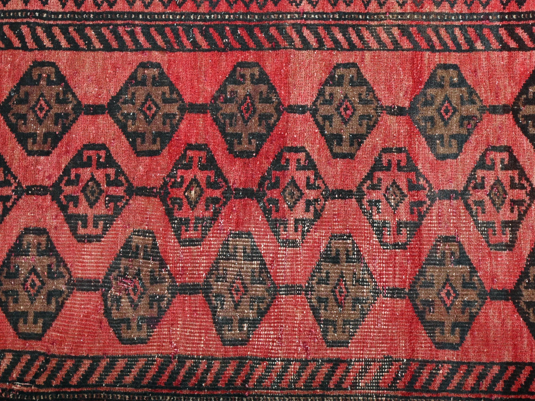 a red and black rug with a pattern of hexagonal shapes